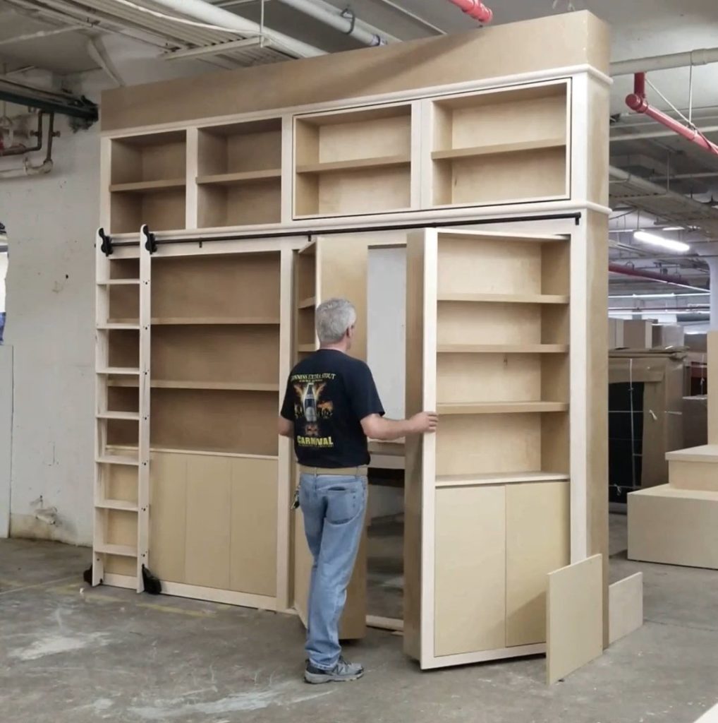 Hiring for your design project: a carpenter inspects an  unpainted wood custom shelving in his workshop.