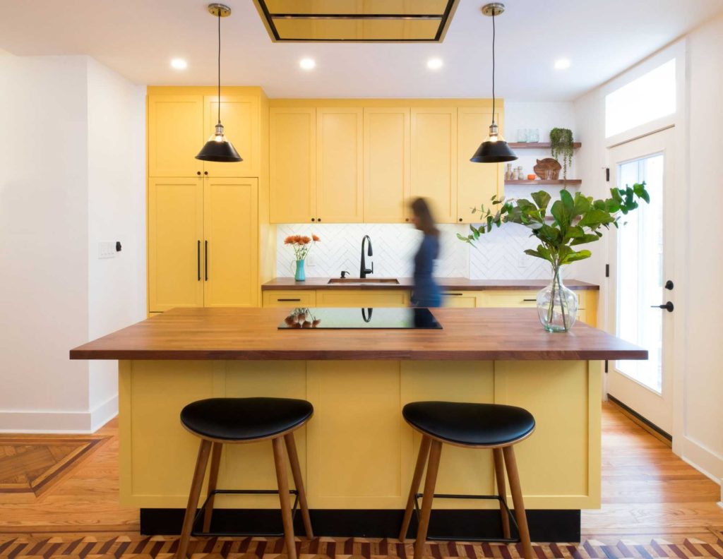 Contemporary kitchen in Brooklyn New York with yellow cabinets and a clean design.