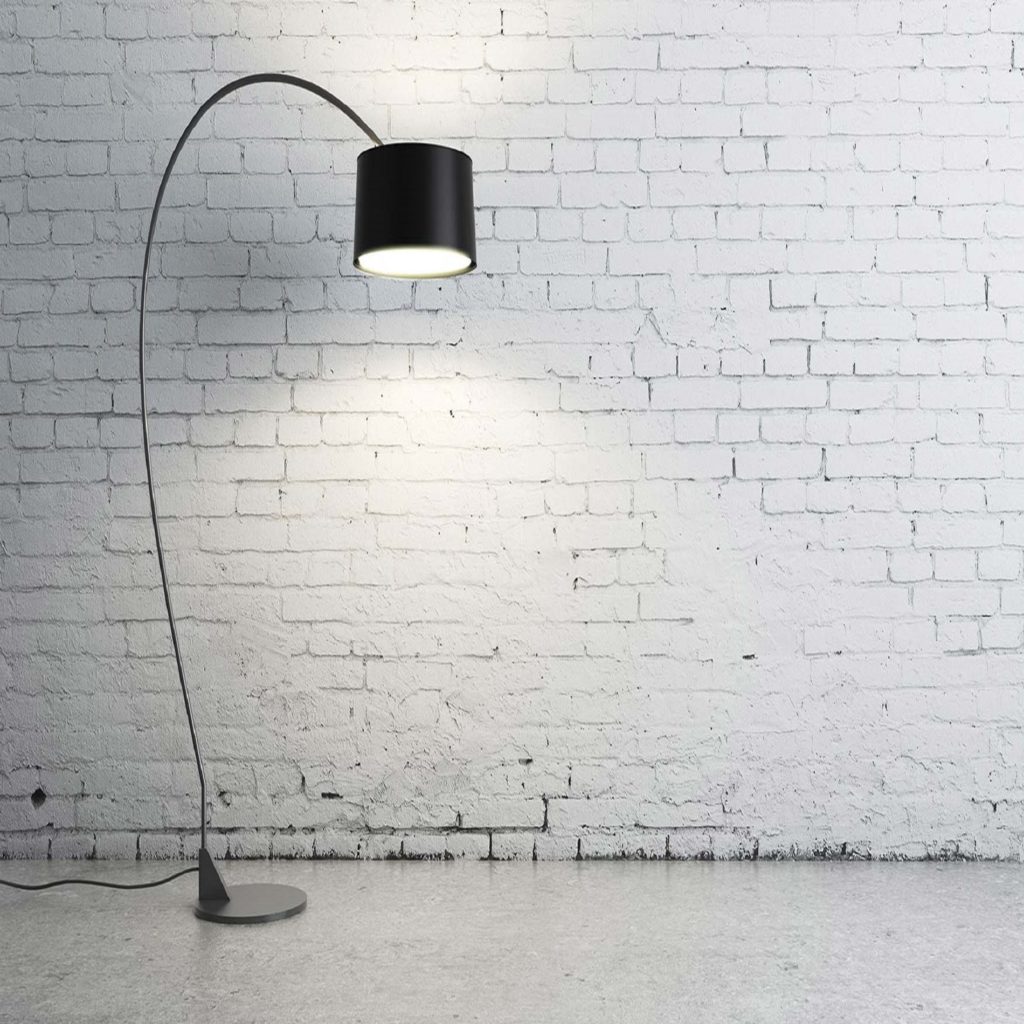 Earth Day: single black floor lamp next to painted white brick wall.