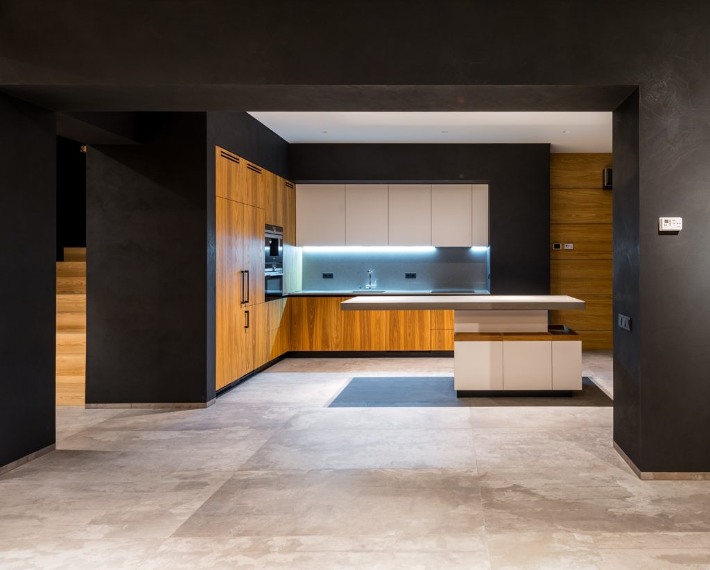 Minimalism and maximalism Part 1: a modern kitchen with dark walls, light floors and wood cabinets.